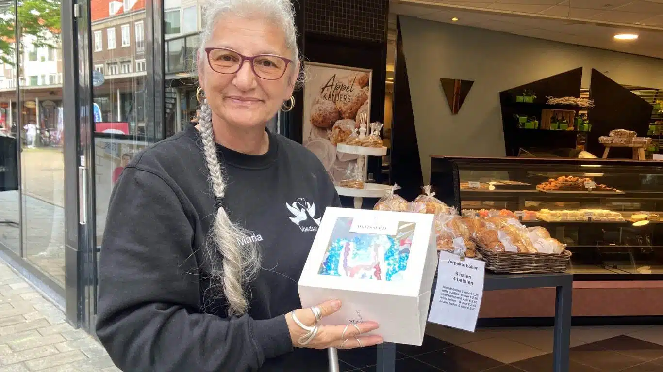 Maria van de Stichting Samen zijn we er voor elkaar staat met een verjaardagstaart in haar handen. Ze heeft deze net opgehaald bij de bakker.